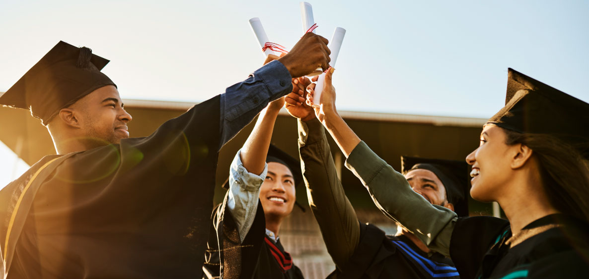 College students cheering with their diploma on graduation day