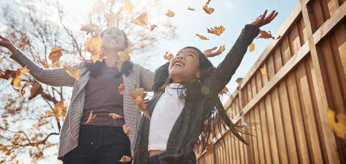 Mom and daughter throwing leaves in the air