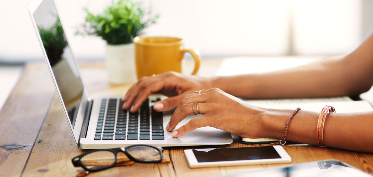 Hands typing on a laptop