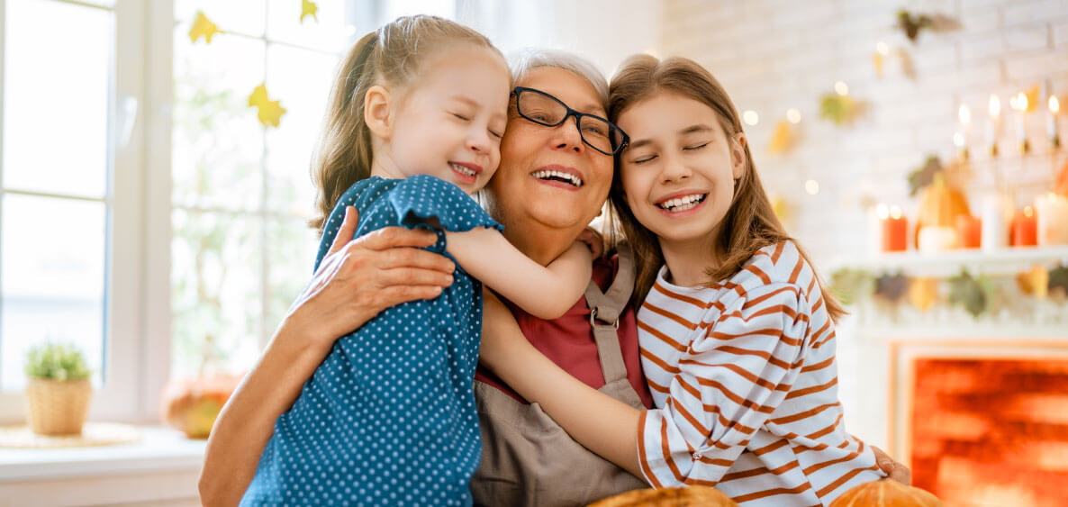 Two grandchildren hugging their grandma