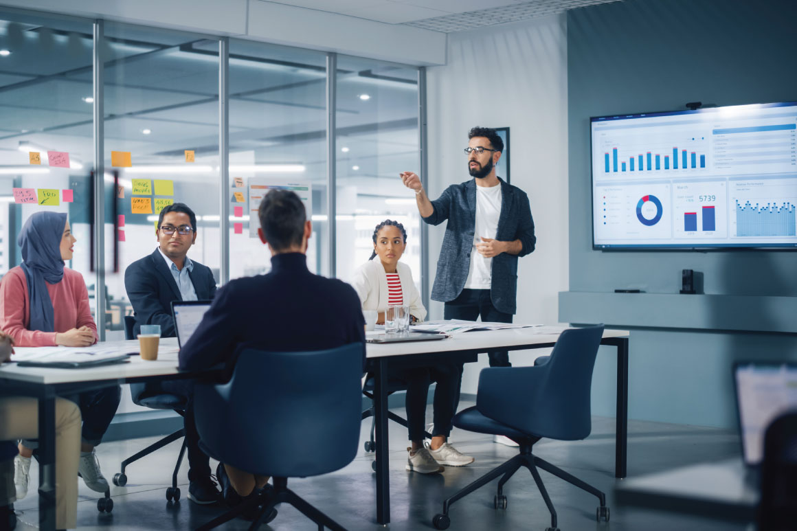 Employees at a meeting together with one person presenting