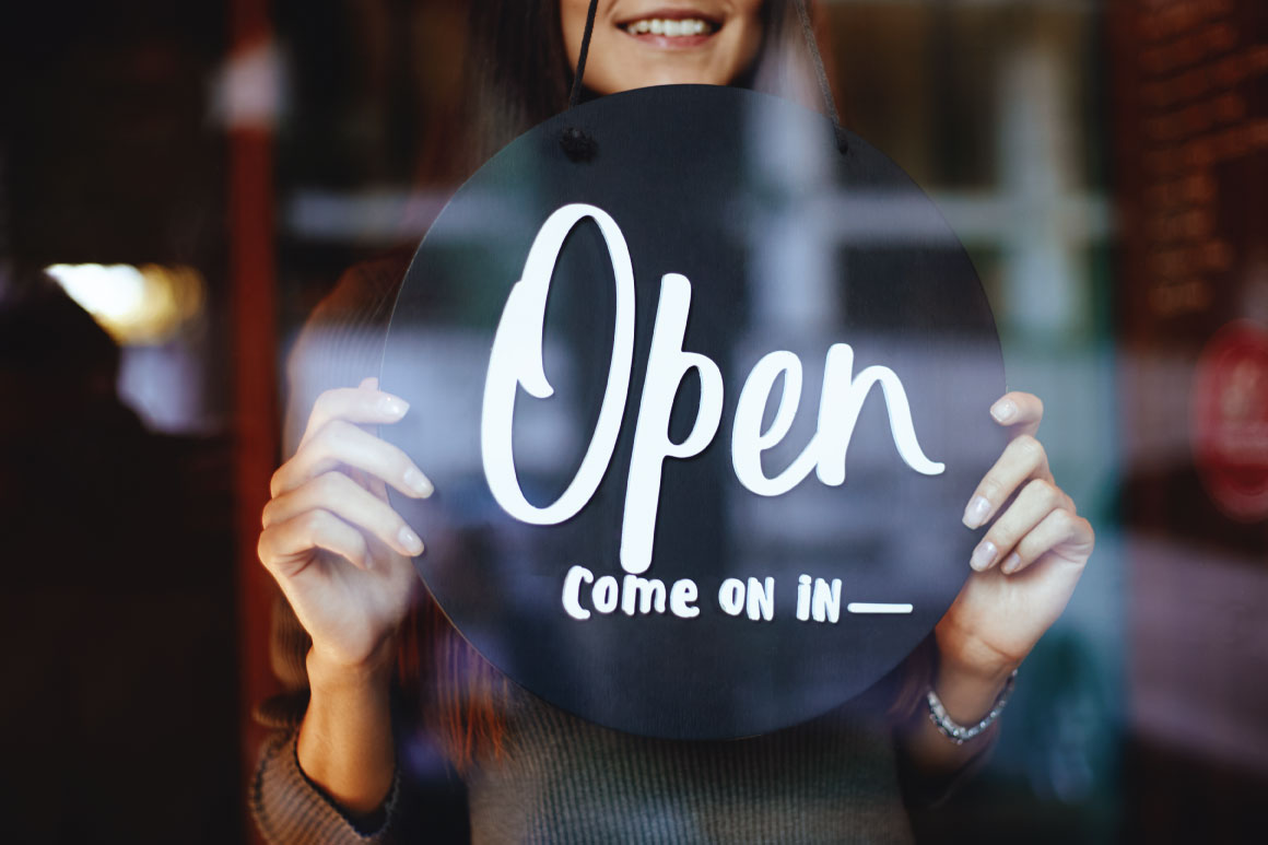 Girl holding Open Come On In sign