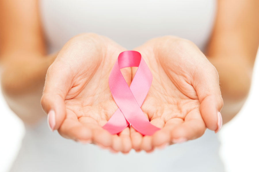Hand holding breast cancer ribbon