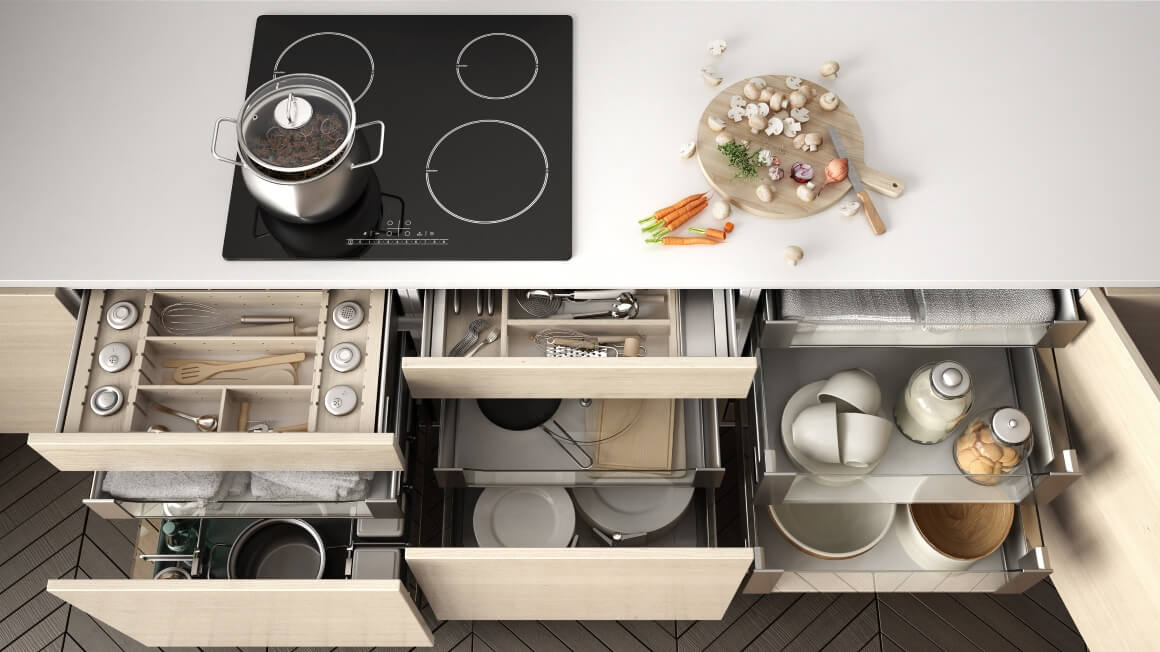 Kitchen cabinet drawers opened with kitchen tools inside