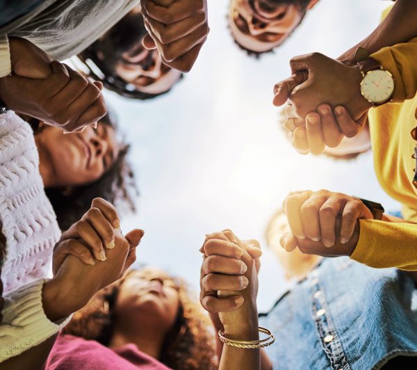 Group of people together holding hands in a circle