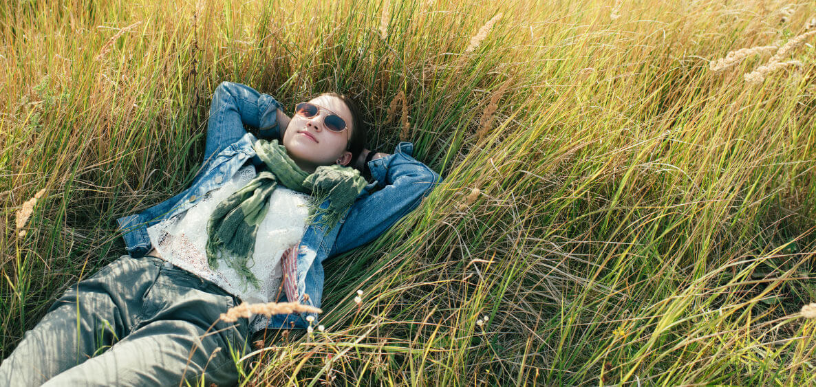 Girl in sunglasses laying on the grass