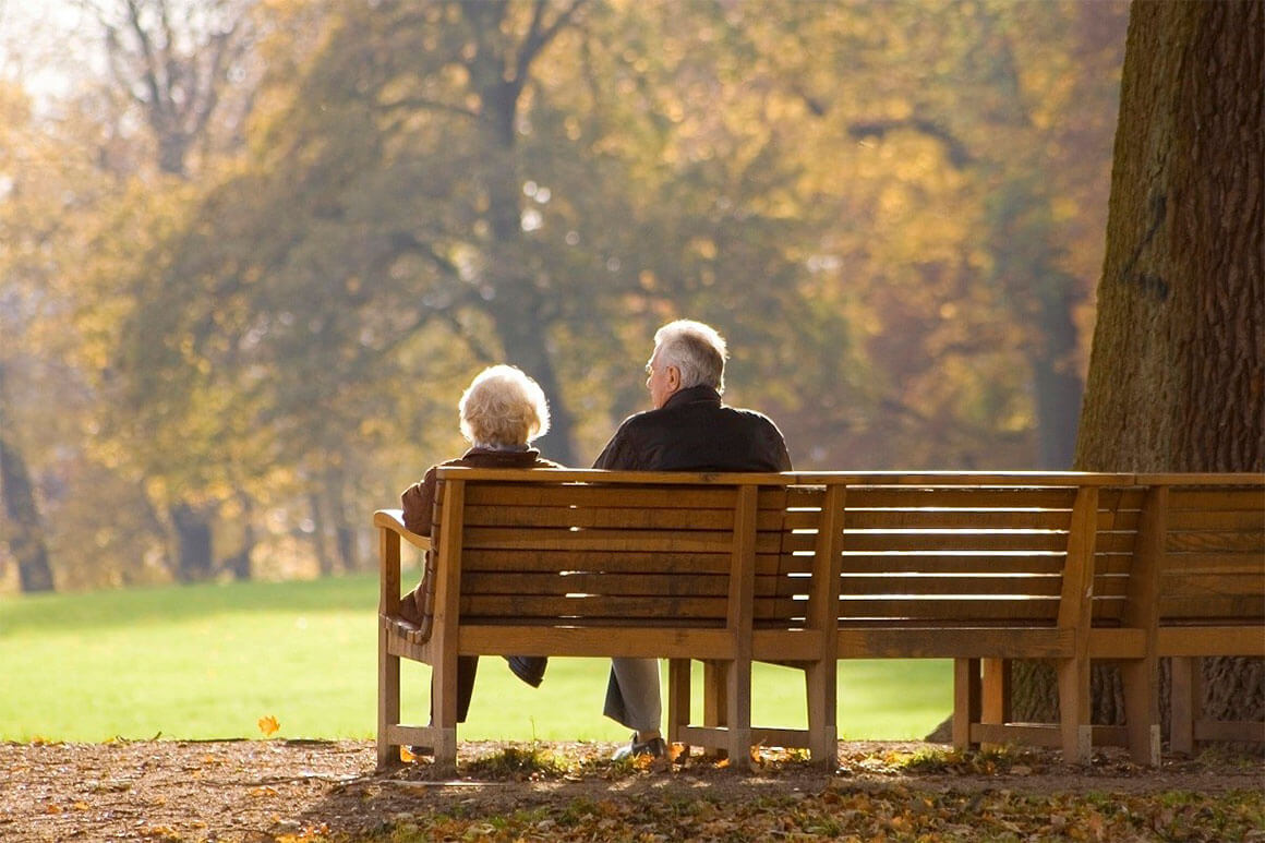 Senior man and woman sitting on a bench at the park