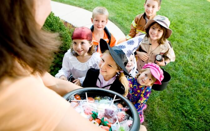 Trick or treaters walking up to a house for some candy