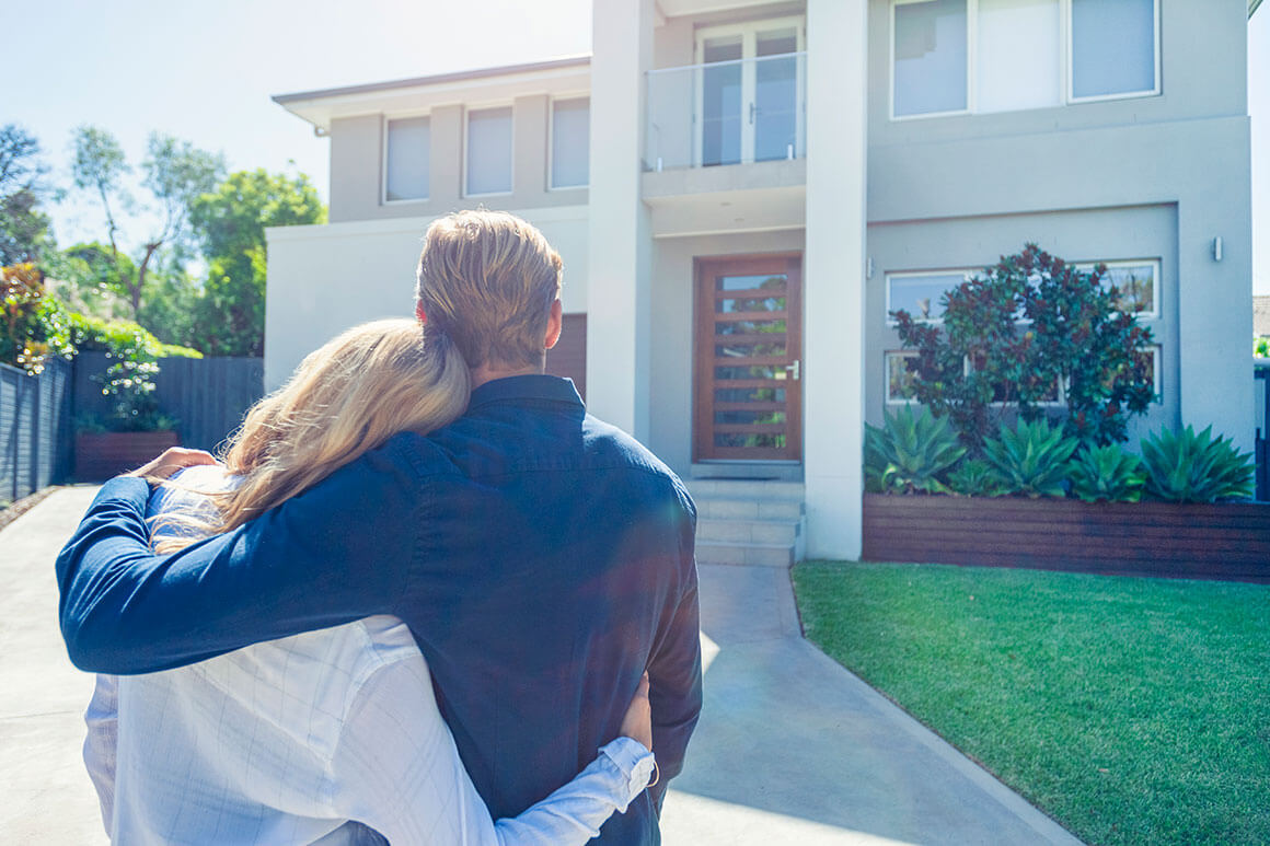 Couple standing outside their house