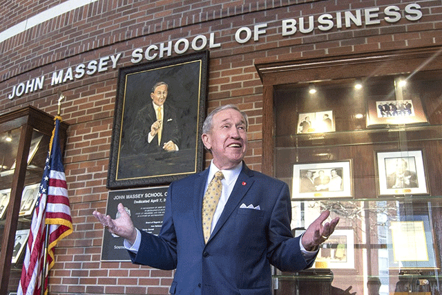 John Massey in front of John Massey School of Business wall at Southeastern Oklahoma State University