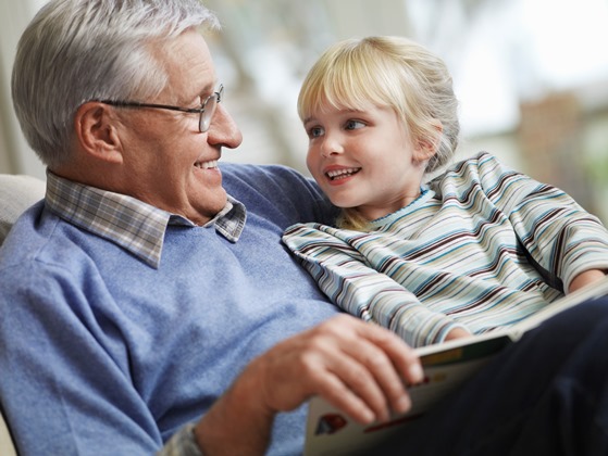 grandpa and grand daughter reading a book together