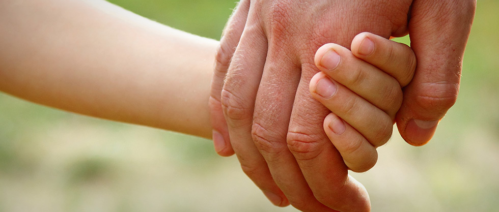 Adult holding a child's hand