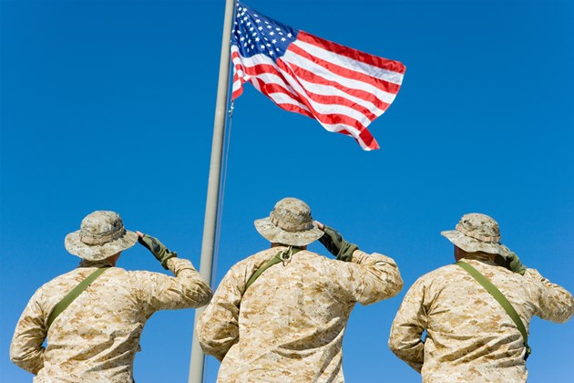 Three soldiers salute to the flag