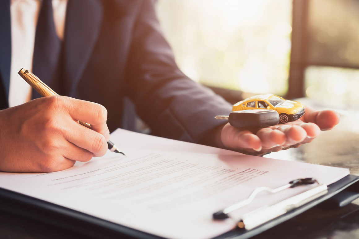 Business person in a suit with a clipboard and holding a key and a toy car