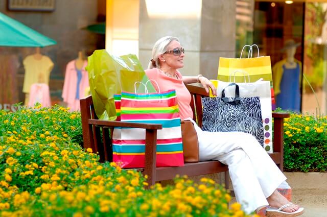 Woman sitting on a bench with shopping bags
