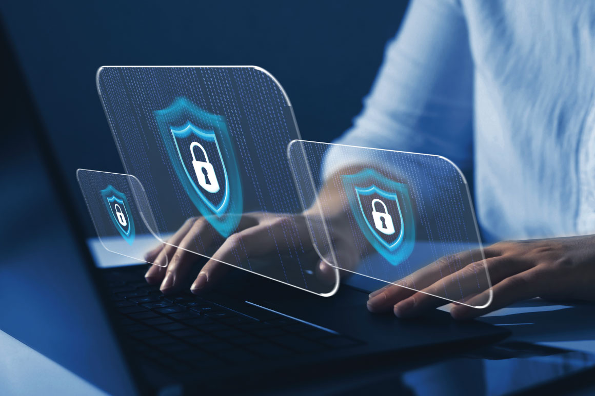 Hands on laptop with security icons and screens