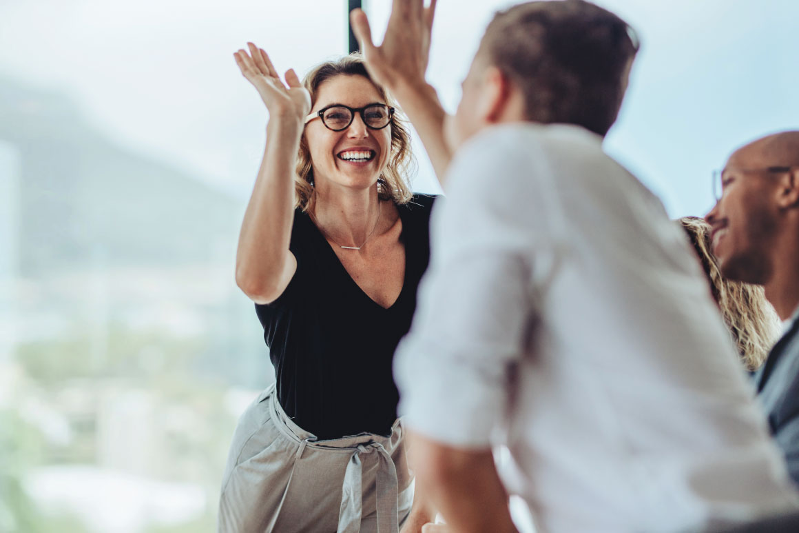Two employees giving one another a high five